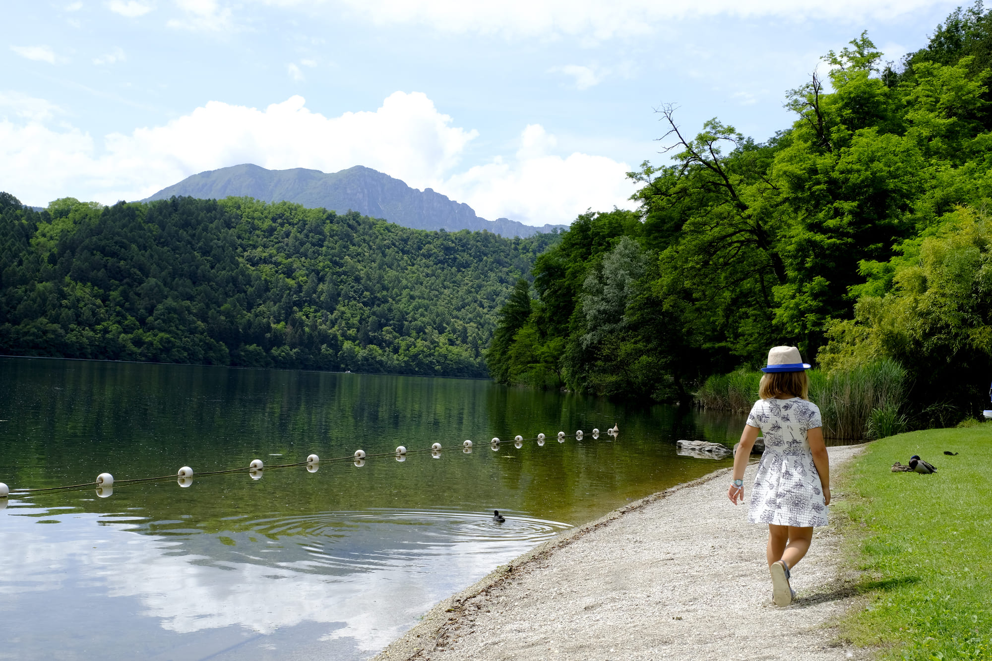 Bambina che passeggia lungo la riva del Lago di Levico, immersa nella natura vicino al Parc Hotel Du Lac