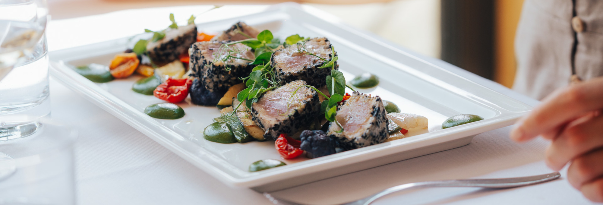 Piatto gourmet di tonno in crosta di sesamo con verdure fresche al Ristorante La Taverna