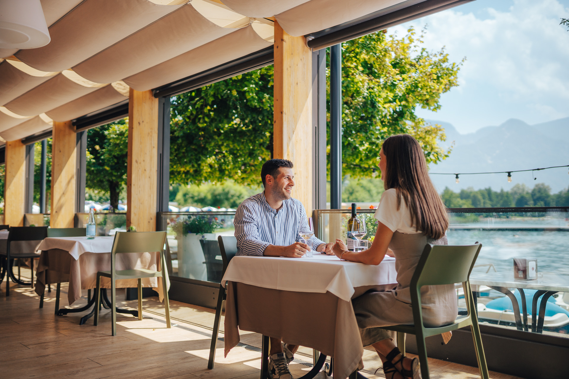 Coppia che pranza al Ristorante La Taverna del Parc Hotel Du Lac, con vista panoramica sul Lago di Levico