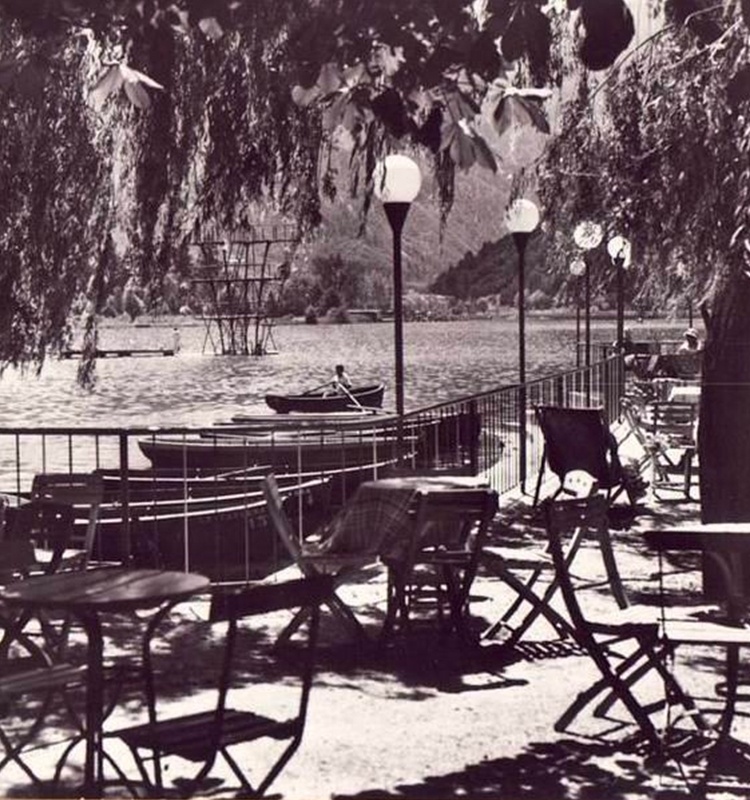 Storica terrazza del Ristorante La Taverna sul Lago di Levico, con tavoli in legno e vista sul lago negli anni passati