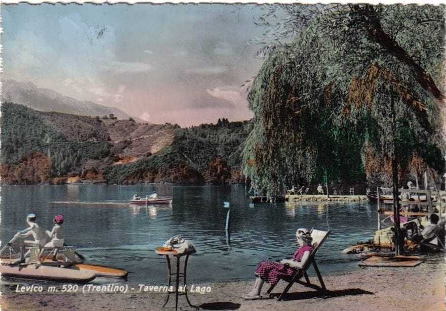 Cartolina vintage del Lago di Levico con bagnanti in riva, pedalò e panorama montano, anni d’oro del turismo trentino