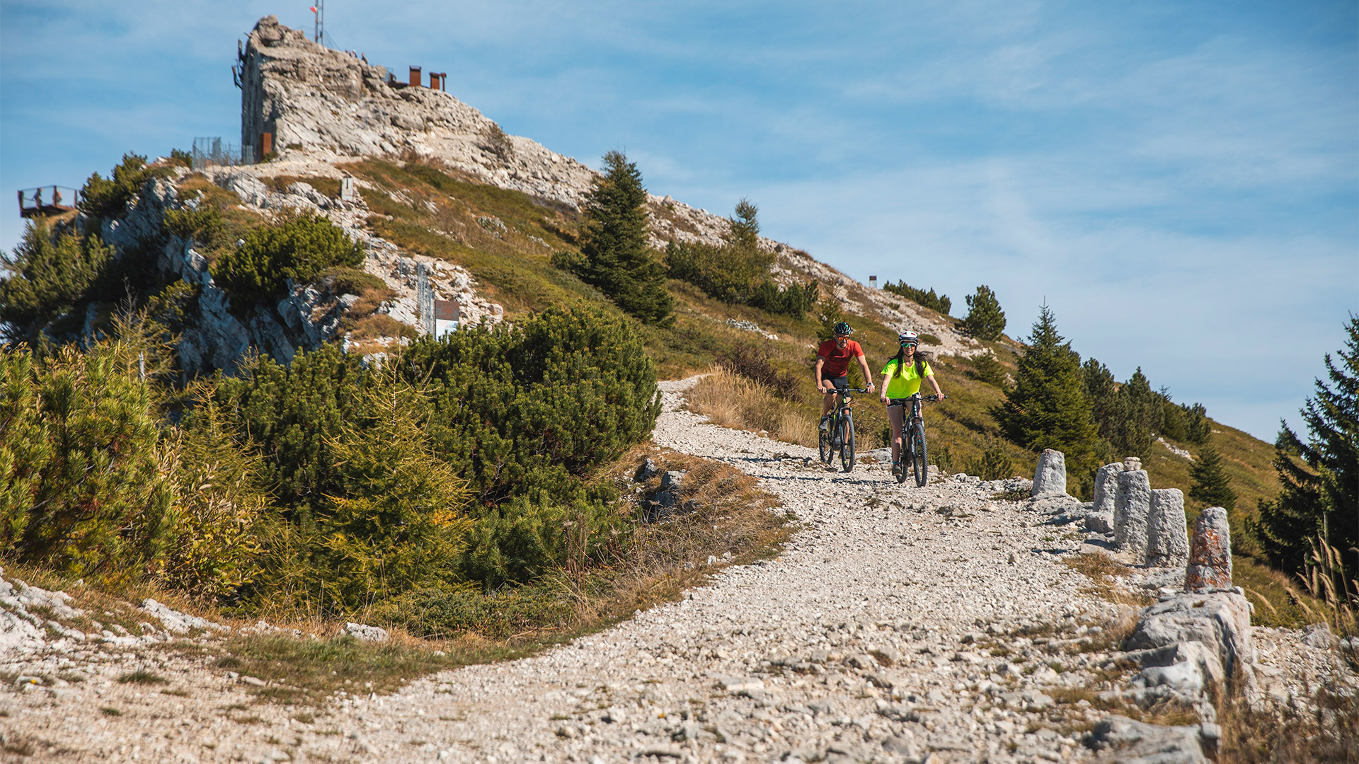 Due ciclisti percorrono un sentiero alpino panoramico in mountain bike.