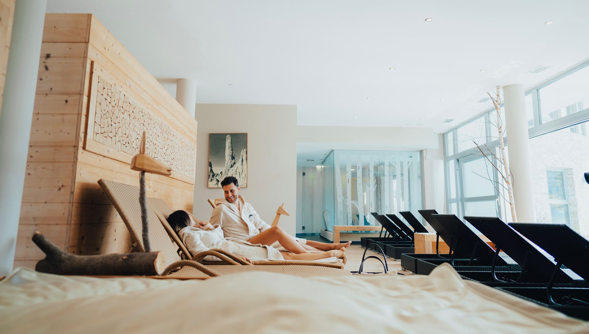 Coppia in accappatoio rilassata su lettini nell’area wellness dell’hotel